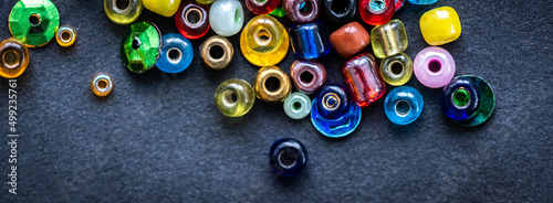 Top view of colorful glass beads on a black background
