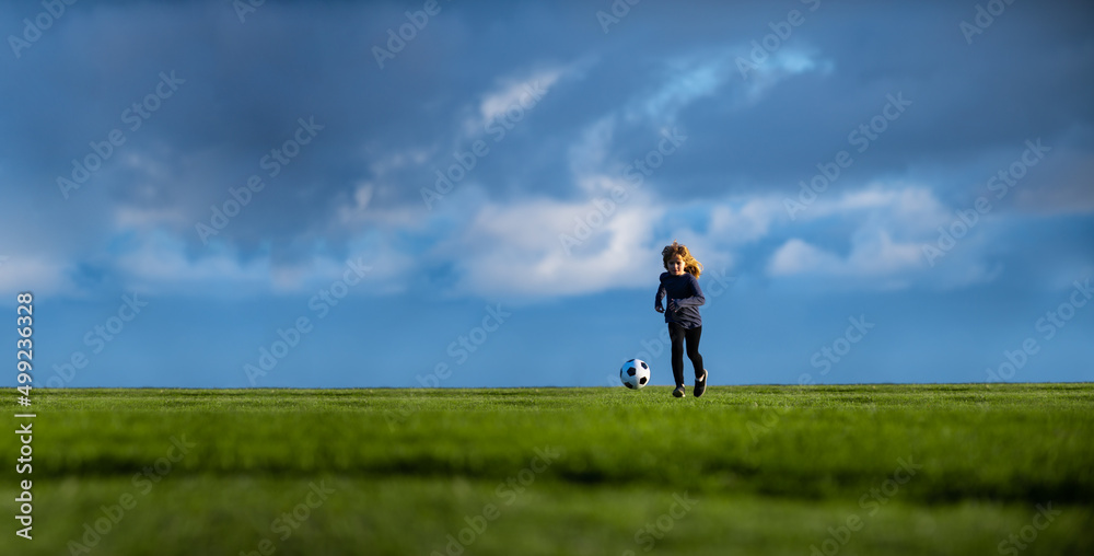 Soccer child play football. Little boy shooting at goal, kid kicking football ball, banner copy space background.