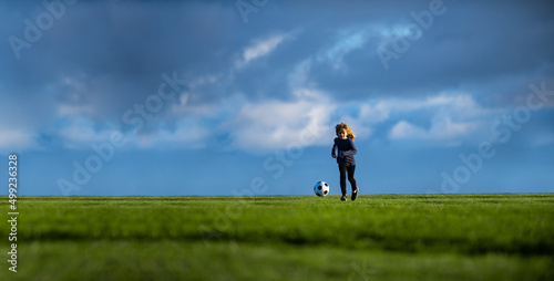 Soccer child play football. Little boy shooting at goal, kid kicking football ball, banner copy space background.