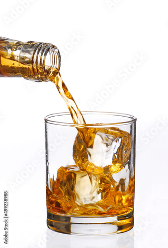 pouring iced whisky glass on white background.
