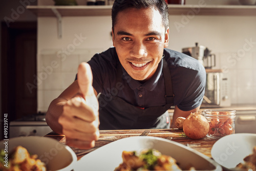 Food fit for a king. Portrait of a young man showing thumbs up while preparing a delicious meal at home.