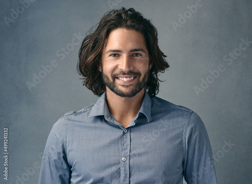 Whats there not to like. Cropped shot of a handsome young man posing against a grey background.