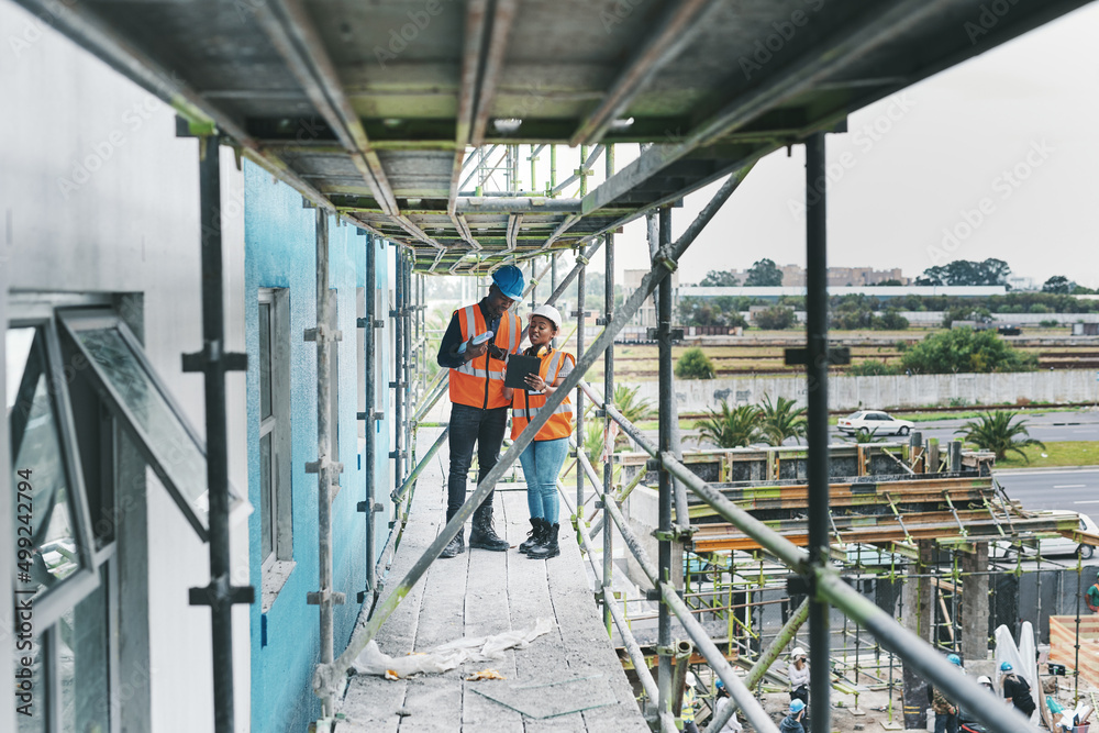 Having organised, digital processes helps keep your project on time. Shot of a young man and woman using a digital tablet while working at a construction site. Having organised, digital processes helps keep your project on time. Shot of a young man and woman using a digital tablet while working at a construction site.