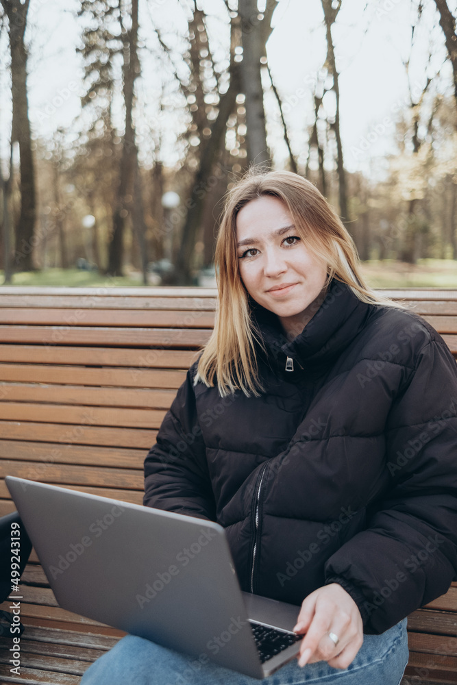 Smiling woman studying on laptop at park Smiling woman studying on laptop at park