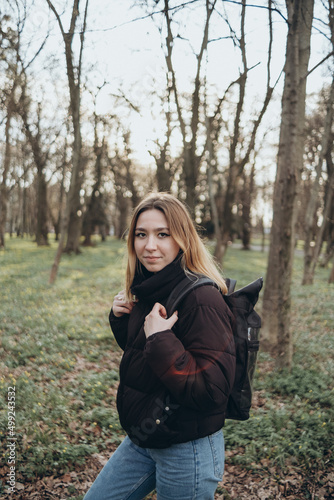 woman traveler with backpack and looking at amazing forest, wanderlust travel concept, space for text, atmospheric epic © Eugene