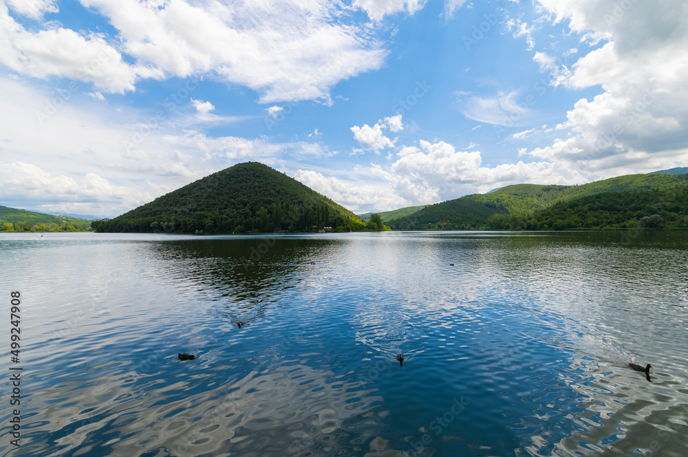 Panorama of Piediluco Lake located in Umbria, on a sunny summer day with blue sky and clouds. Near the Marmore Falls. Italy.