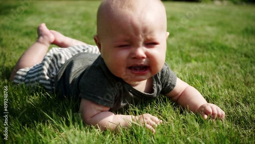 child lies on grass on and cries slow motion