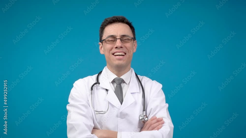 Smiling physician with crossed arms. Blue background Smiling physician with crossed arms. Blue background