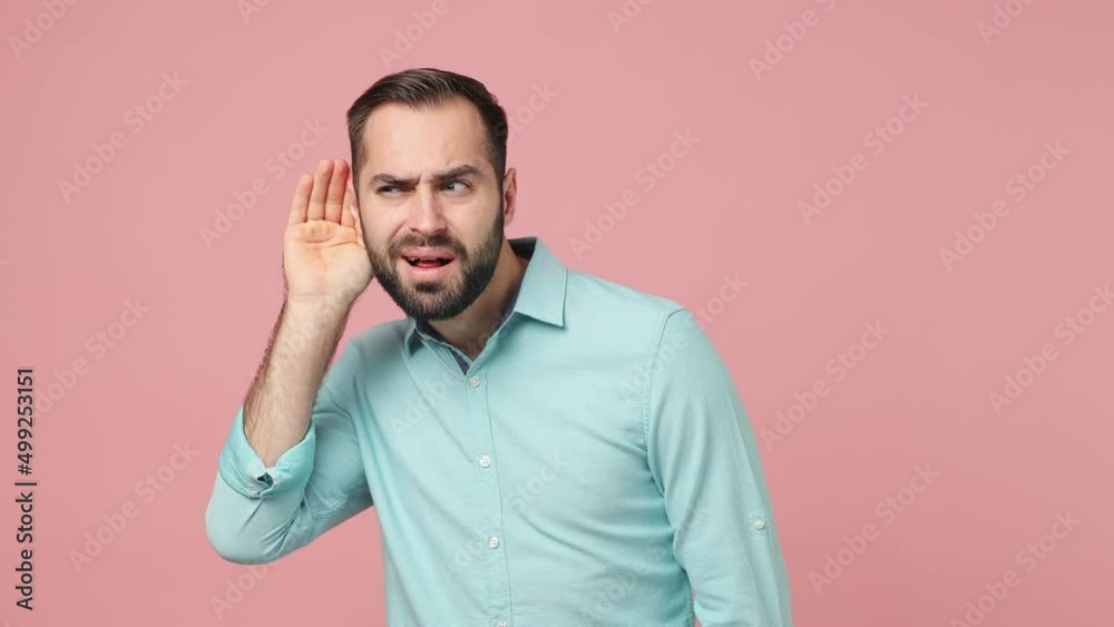 Curious nosy fun young brunet man 20s years old wears blue shirt try to hear you overhear listening intently hot news isolated on plain plain pink background studio. People emotions lifestyle concept Curious nosy fun young brunet man 20s years old wears blue shirt try to hear you overhear listening intently hot news isolated on plain plain pink background studio. People emotions lifestyle concept
