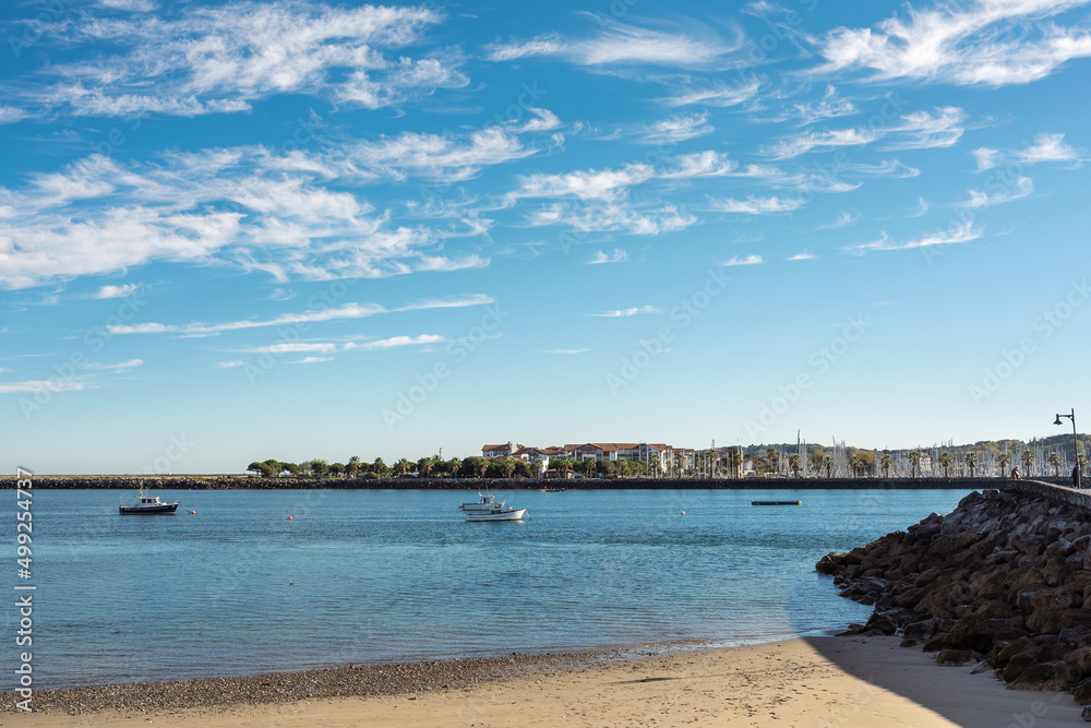 Beach next to the pier with fishing boats in the town of Hondarribia