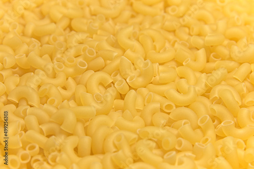 Dry raw yellow pasta. Close-up. Completely background.