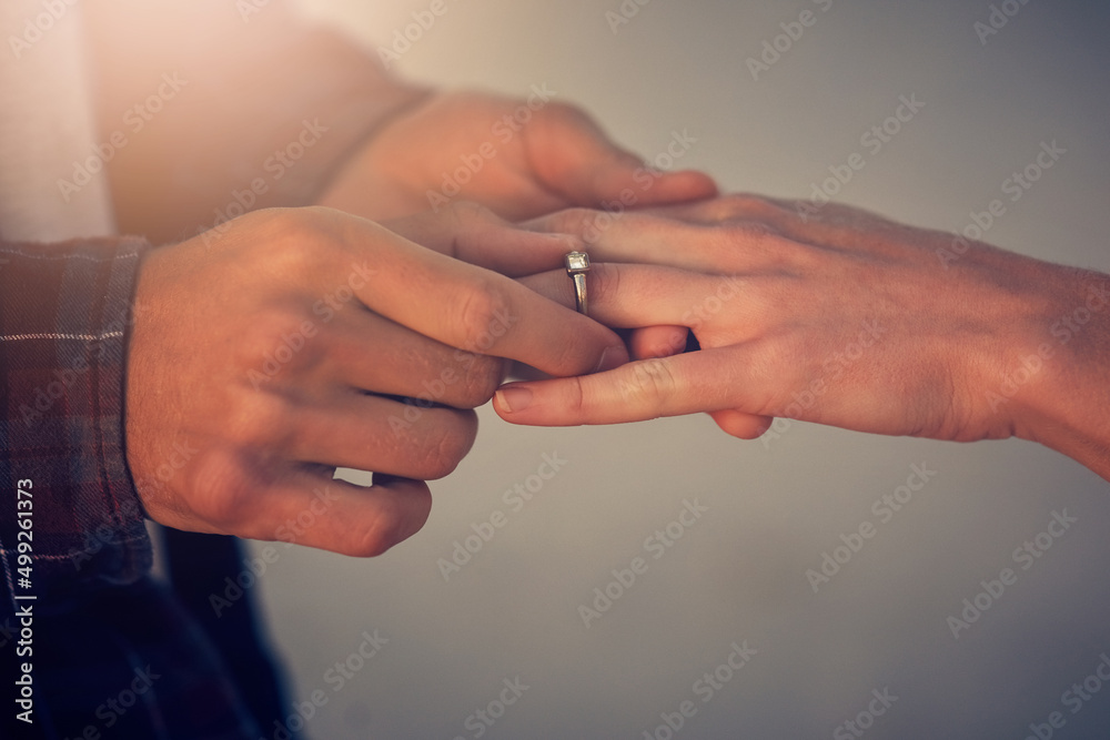 Its time for the next step. Cropped shot of a young man putting an engagement ring on his girlfriends finger.