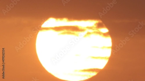 footage of Full sun with bright round sunlight heat wave and a group of moving clouds in the morning