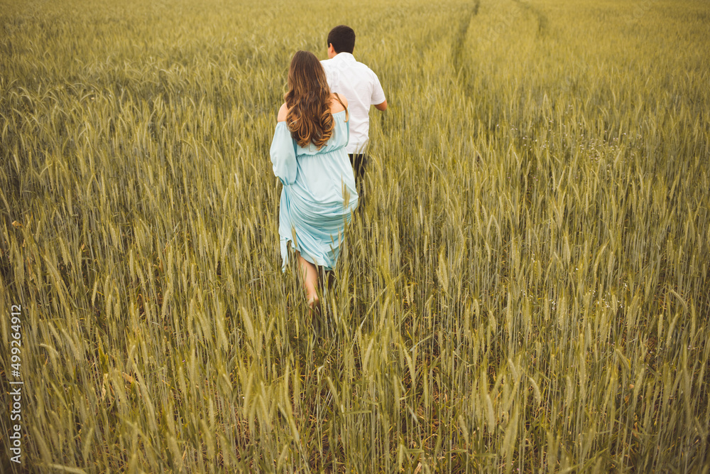 couple walking in a wheat field couple walking in a wheat field
