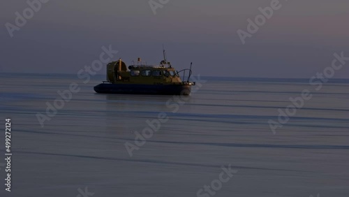 Hovercraft on frozen ice surface of the Baikal lake at sunset. Khivus - transport on ice, 4k photo