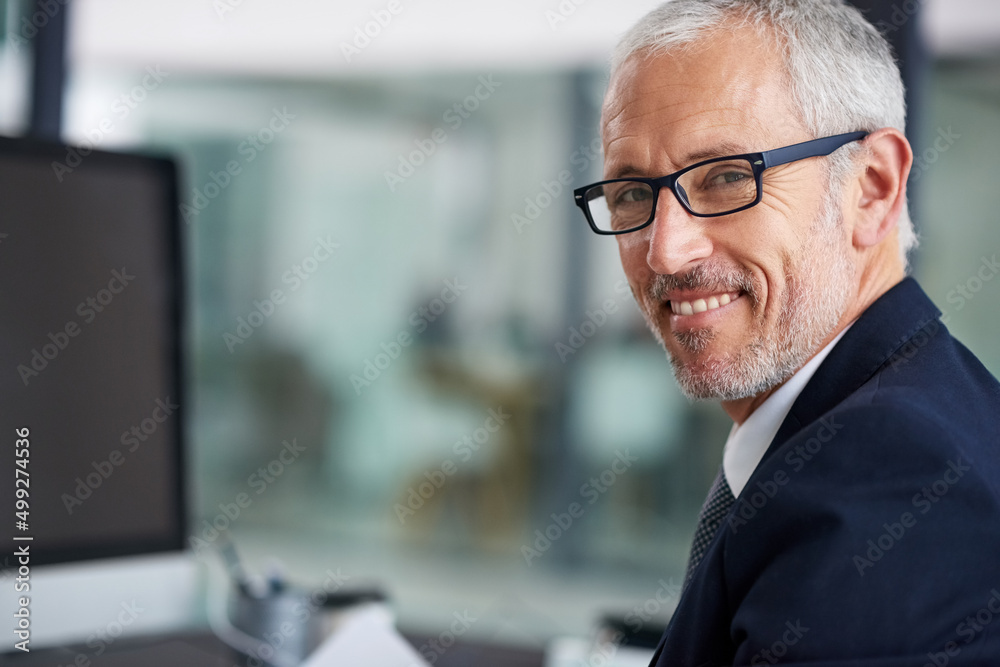 Ive got success covered. Portrait of a smiling mature businessman working at his desk in an office. Ive got success covered. Portrait of a smiling mature businessman working at his desk in an office.