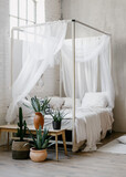 White baldachin over bed in boho chic style bedroom