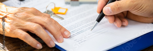 Real Estate Agent Helping Client In Filling Contract Form