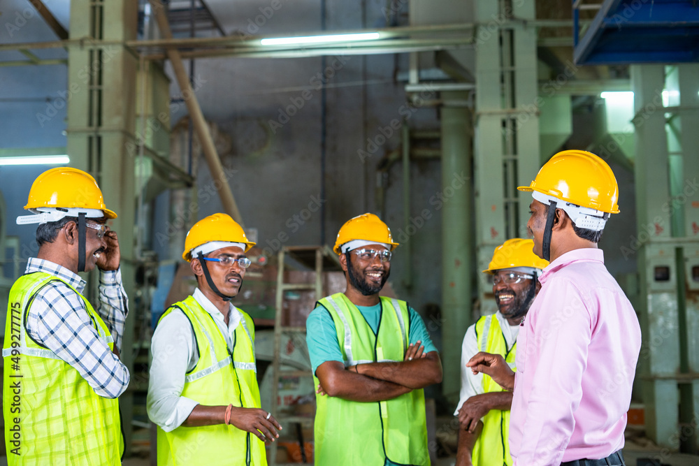 focus on manager, group of industrial workers having fun chat with supervisor at factory - concpet teamwork, collaboration and communication focus on manager, group of industrial workers having fun chat with supervisor at factory - concpet teamwork, collaboration and communication
