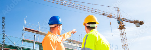 Фотография Two Male Engineers Supervising The Construction Site