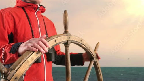 Captain Holding Hands on Ship Rudder and Looking in Binoculars For The Way Forward.