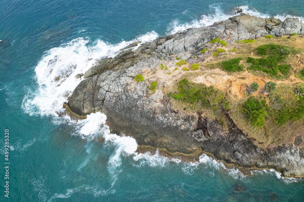 Aerial view Top down seashore big wave crashing on rock cliff Beautiful sea surface in sunny day summer background Amazing seascape top view seacoast at Phuket Thailand
