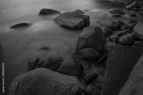 Waves over the rocks at the seashore in black and white Long exposure photography © panya99