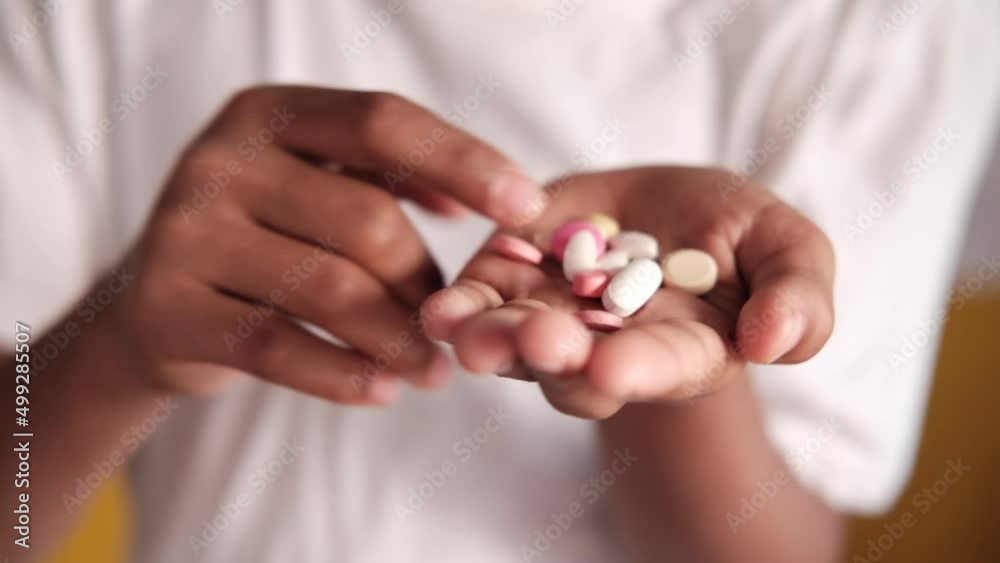 man's hand with medicine spilled out of the pill container man's hand with medicine spilled out of the pill container