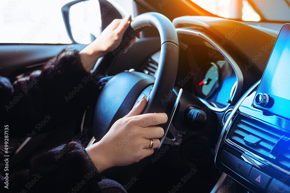 Woman driving car background with female hands holding steering wheel.
