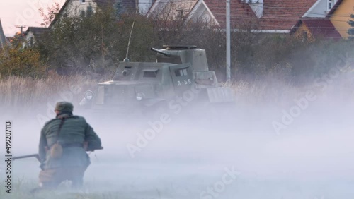 Ukrainian partisans of World War 2 fight against Bolshevik troops. Soviet enemy tank in background. Soldier with a gun sneaks up on the enemy. National liberation struggle of Ukraine