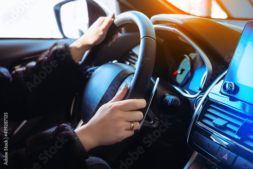 Woman driving car background with female hands holding steering wheel. © Dmytro