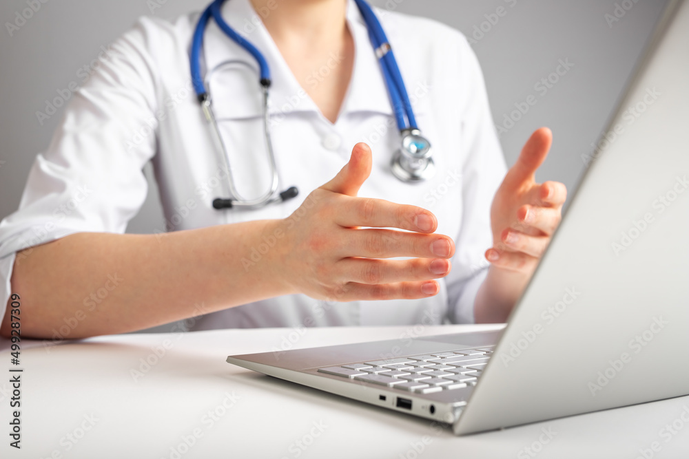Doctor with stethoscope giving online consultation to patient. Healthcare and telemedicine concept. Woman in lab coat treating sick people using laptop and Internet. High quality photo Doctor with stethoscope giving online consultation to patient. Healthcare and telemedicine concept. Woman in lab coat treating sick people using laptop and Internet. High quality photo