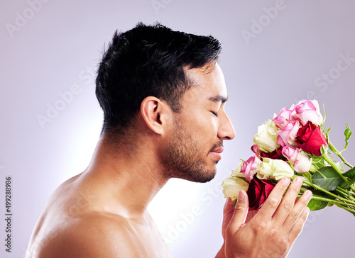 Flowers will make anyones day. Studio shot of a handsome young man posing with a bunch of roses. photo