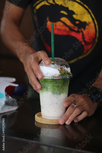 Iced matcha green tea with green straw                        