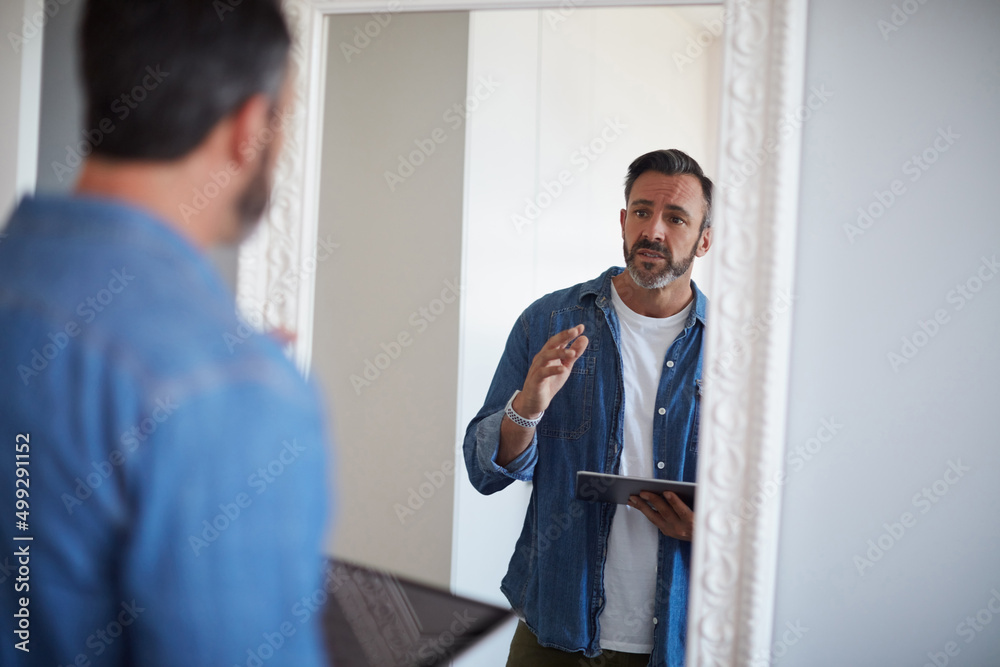 Fototapeta premium Okay you gotta do better than this. Cropped shot of an attractive mature man having a rehearsal in the mirror while holding a digital tablet.