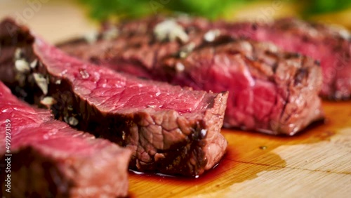 bloody beef steak slices on wooden board
