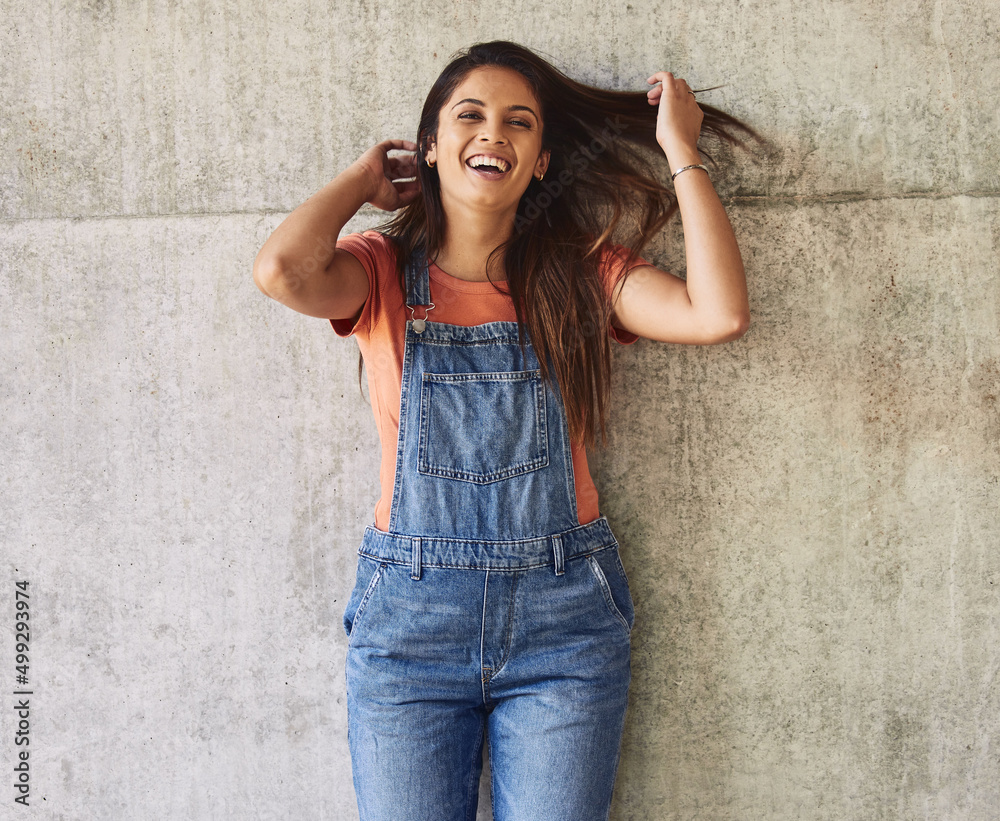 Young, gifted and amazing. Portrait of a beautiful young woman tossing her hair and laughing against an urban background. Young, gifted and amazing. Portrait of a beautiful young woman tossing her hair and laughing against an urban background.