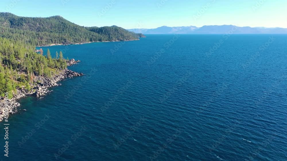 Aerial View Over Idyllic Lake Champlain In New York and Vermont with Clear Blue Water, Pine Tree Forest and Rip Rap Rocky Shoreline- drone shot Aerial View Over Idyllic Lake Champlain In New York and Vermont with Clear Blue Water, Pine Tree Forest and Rip Rap Rocky Shoreline- drone shot