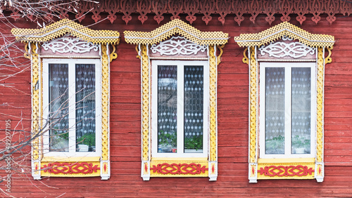 Windows with carved wooden architraves. Facade of typical russian merchant house. © IrinaK