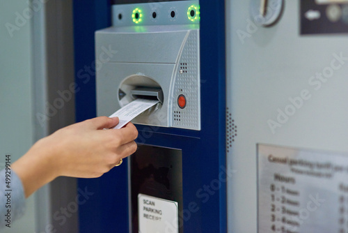 Pay or stay. Cropped shot of an unrecognizable person inserting a ticket into a meter. photo