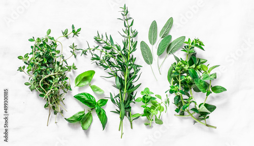 Fragrant herbs for cooking food on a light background, top view