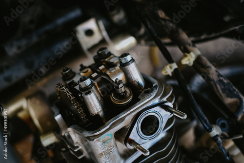 Set the valve on the cylinder head of the motorcycle engine by a technician.