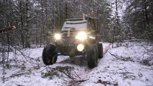 Two utv sxs off-road vehicles with the headlights on in the evening snow forest