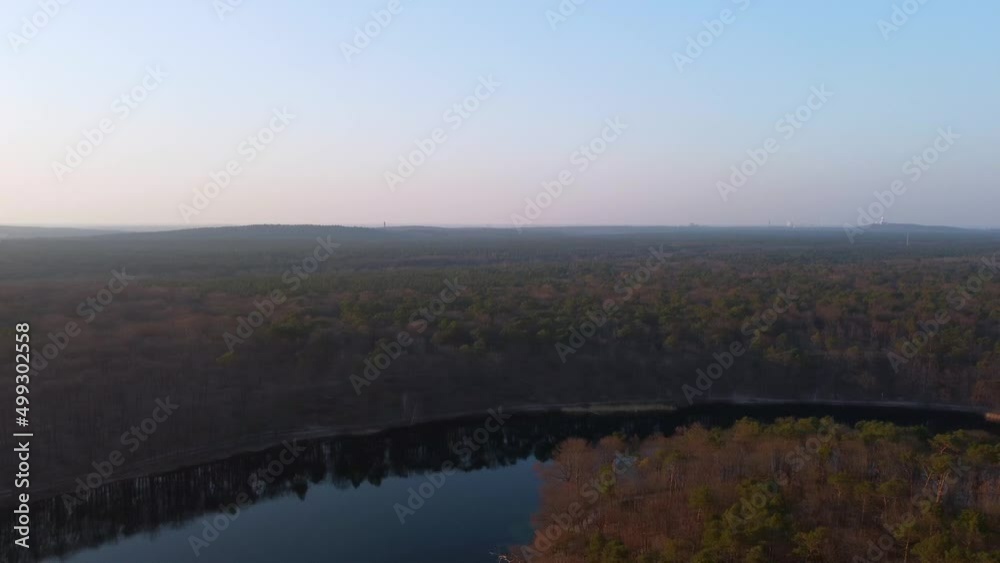 Great high aerial view flight panorama curve flight drone footage at sunset no clouds in sky in the woods on a forest lake in Berlin Germany. Cinematic view from above by Philipp Marnitz spring 2022 Great high aerial view flight panorama curve flight drone footage at sunset no clouds in sky in the woods on a forest lake in Berlin Germany. Cinematic view from above by Philipp Marnitz spring 2022