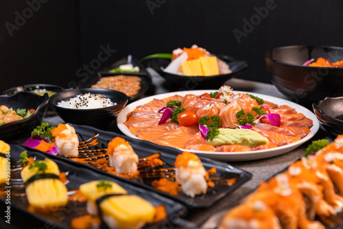 Sashimi sushi set with soy on black background.Assorted sushi set served on dark stone slate background. Top view
