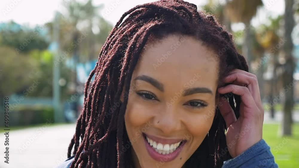 Young beautiful woman with dreadlocks hairstyle smiling at camera. Young beautiful woman with dreadlocks hairstyle smiling at camera.