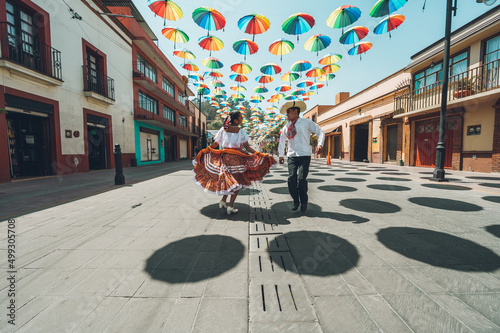 Dancers of typical Mexican dances from the central region of Mexico, doing their performance in the street adorned with colored umbrellas. photo