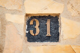Número treinta y uno sobre pared de ladrillos