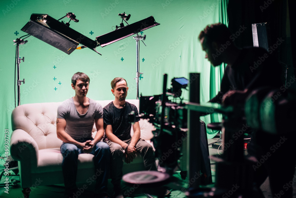Professional male actors work in the frame on the set. Shooting with actors on a big green chroma key. Professional male actors work in the frame on the set. Shooting with actors on a big green chroma key.