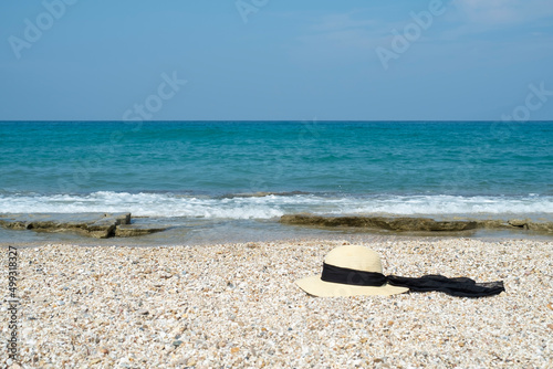 Straw hat with black ribbon on the beach